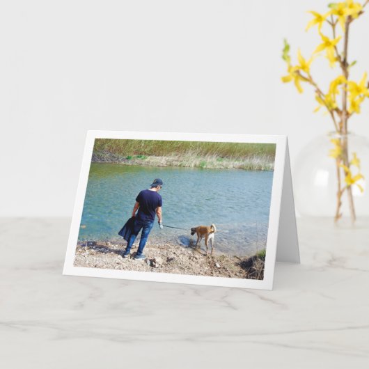 川で犬と一緒の男性 カード (黄色い花)