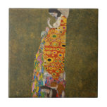 『希望II』（1907/08） by Gustav Klimt、ヴィンテージ アートヌーボー タイル<br><div class="desc">『希望II』（1907/08） by Gustav Klimt は、ヴィクトリア時代のシンボリズムを特徴とする、美しいヴィンテージ絵画です。妊婦がお腹を見つめている様子が描かれており、その近くには3人の女性が彼女の着物の複雑な模様に織り込まれています。彼女の胸は露出し、PG-13指定となっています。
アーティストについて:
グスタフ・クリムト（1862-1918）は、オーストリアのシンボリスト画家であり、ウィーンのアートヌーボーの最も著名なメンバーの一人です。</div>
