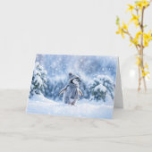 帽子をかぶった雪の中のペンギンのクリスマス カード (黄色い花)
