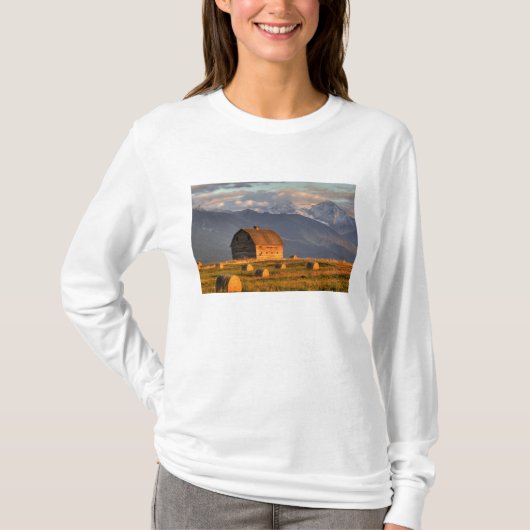 干し草の俵に囲まれた古い納屋とドラマチックな Tシャツ (正面)