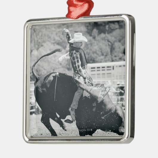 強く反対する雄牛にしがみつくライダーの側面図 メタルオーナメント (左)
