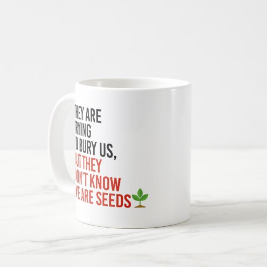 彼らは私たちを埋葬しようとしているが、私たちは種である コーヒーマグカップ (正面左)