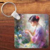 彼女の手の中の花を称賛する女の子 キーホルダー (正面)