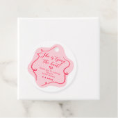 彼女はレトロな波色のピンクと赤の結び目を結んでいる フェイバータグ (インサイチュ)