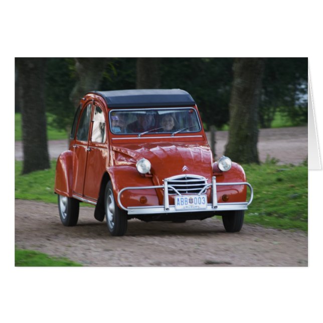 微笑む女性と古い赤いシトロエン2CV (正面横)