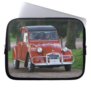 微笑む女性と古い赤いシトロエン2CV ラップトップスリーブ