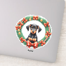 愛らしいクリスマスのドーベルマン子犬がフェスティブなリースの中に シール