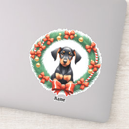 愛らしいクリスマスのドーベルマン子犬がフェスティブなリースの中に シール