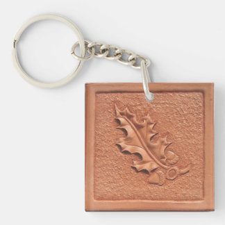 手によって用具を使われる革カシの葉のアクリルKeychain キーホルダー