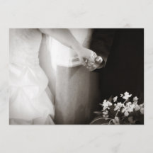 手の結婚式招待状を握っている新郎新婦