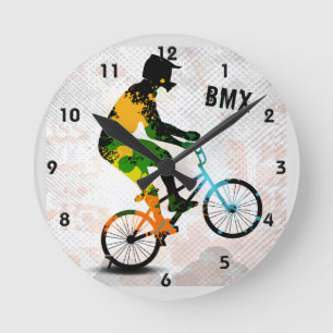 抽象的なペンキのBMXのライダーは文字とのスクエアをはね飛ばします ラウンド壁時計