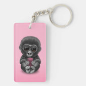 携帯電話のピンクを保持しているかわいいベビーのゴリラ キーホルダー (裏面)