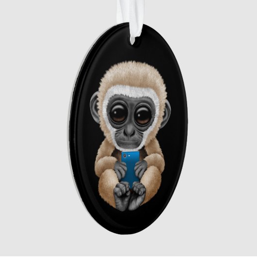 携帯電話の黒を保持しているかわいいベビーのテナガザル オーナメント (正面)