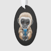 携帯電話の黒を保持しているかわいいベビーのテナガザル オーナメント (正面)