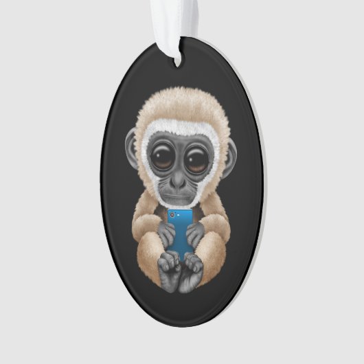 携帯電話の黒を保持しているかわいいベビーのテナガザル オーナメント (正面)