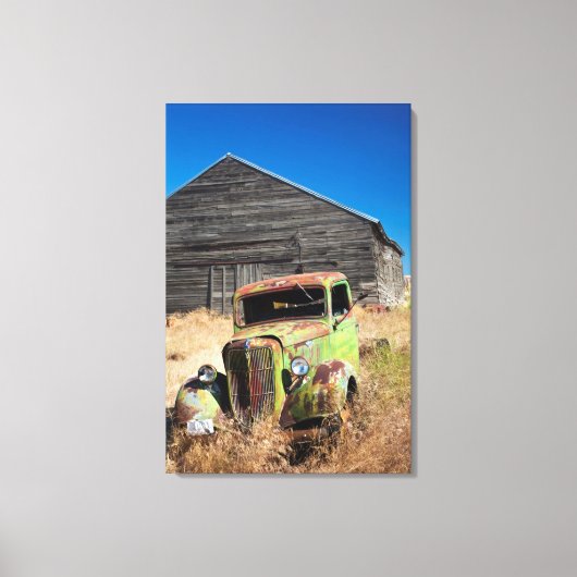 放置された農場の前で錆びた車 キャンバスプリント (正面)