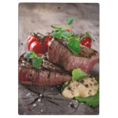 新しいハーブおよびトマトが付いている焼かれたbbqのステーキ クリップボード (裏面)