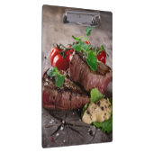 新しいハーブおよびトマトが付いている焼かれたbbqのステーキ クリップボード (右)