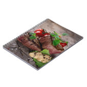 新しいハーブおよびトマトが付いている焼かれたbbqのステーキ ノートブック (左側)