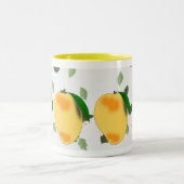 新鮮なジューシーな黄色のマンゴーと緑離れの ツートーンマグカップ (中央)