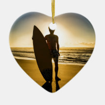 日の出の間のサーファーのシルエット