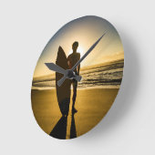 日の出時のサーファーのシルエット ラウンド壁時計 (傾斜)