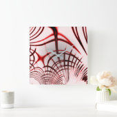 明るい背景に交差する赤い曲線のトレース スクエア壁時計 (ホーム)