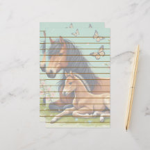 春の風景で休息する馬と子馬