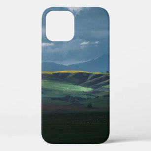 昼間の曇り空の緑の草原 iPhone 12ケース