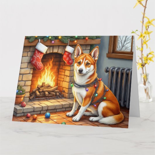 暖炉のそばに座るバセンジーとクリスマスのイルミネーション カード (黄色い花)