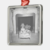 暖炉の前に坐っているミニチュアプードル メタルオーナメント (左)