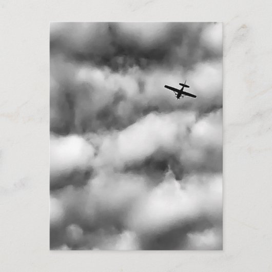 曇り空を飛ぶ小型飛行機の写真 ポストカード (正面)