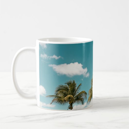 朝青空の下の緑のヤシの木 コーヒーマグカップ (左)