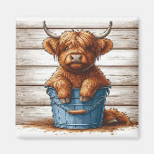 木材の壁に対する青いバケツのハイランドカウカーフ マグネット (正面)