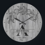 木製のログハウス風 ファミリー ネーム モノグラム ラージ壁時計<br><div class="desc">素朴な木製ファームハウスの家族名のモノグラム時計のデザインに、花の要素を添えて。美しい素朴な木目のテクスチャが特徴の、繊細な花のアクセントとカスタムの家族名、クラシックなファームハウス風のタイポグラフィーのモノグラムが施された、温かみとチャームのある壁時計。リビングルーム、キッチン、エントランス、またはキャビンに、ボタニカルなエレガンスを添えた、コージーなカントリー風の雰囲気を加えるのに最適。家暖まり、結婚式、結婚記念日、母の日、または素朴なファームハウススタイルが好きな家族への、思いやりのあるパーソナライズされたギフト。家族名とイニシャルでカスタマイズして、独自のものに。ゴールデンブルームホームによるオリジナルでユニークなデザイン。</div>