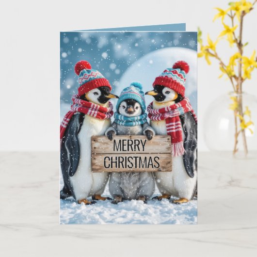 木製の看板を持つクリスマスファミリーペンギン カード (黄色い花)
