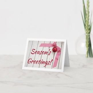 木製の赤いベルと赤いチェックのボウが付いたクリスマス カード