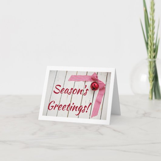 木製の赤いベルと赤いチェックのボウが付いたクリスマス カード (正面)