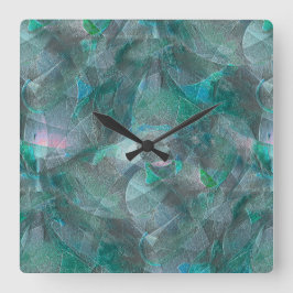 未完成の壁の漆喰の上にスポッティング緑がかったシアン スクエア壁時計