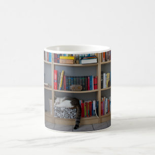 本だなの図書館の本で眠っているかわいい猫 コーヒーマグカップ