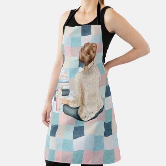 本とホット飲料を持って座っている女性 エプロン (インサイチュ)