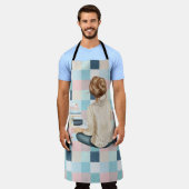 本とホット飲料を持って座っている女性 エプロン (着用した状態)