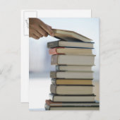 本の積み重ねからの本を取る人の手 ポストカード (正面/裏面)