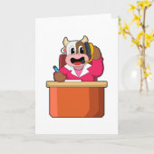 机の前に座る牛の秘書 カード (黄色い花)