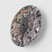 柱時計をくちばしでつついているPileatedのキツツキ ラウンド壁時計 (傾斜)