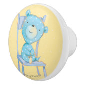 椅子で微笑している青いさらさくま セラミックノブ (右)