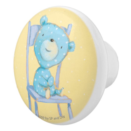 椅子で微笑している青いさらさくま セラミックノブ (右)