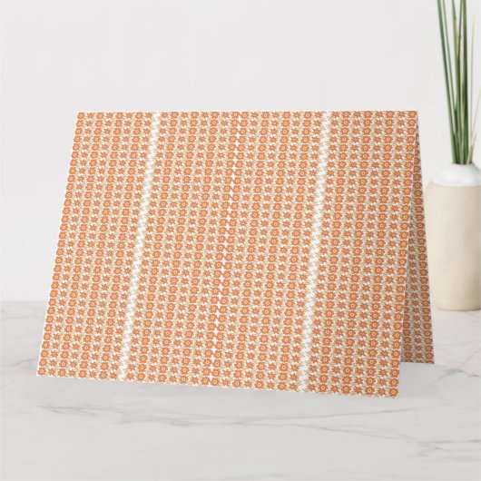 模様の入ったオレンジ色の敷物が平らに置かれている カード (正面)
