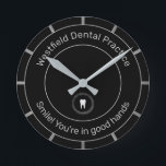 歯科医パーソナライズされた事務所Lモットタグラインブラック ラウンド壁時計<br><div class="desc">おもしろいを顧客のスマイルに追加する顔。歯医者や歯科矯正医に最適。曲線に薄い灰色の文字を持つ美しい黒で歯のイメージで。上に練習の名前を追加し、下に紹介文やモットーを追加しもします。</div>
