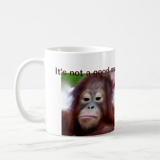気難しいオランウータンの動物の顔 コーヒーマグカップ (左)